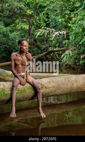 Korowai-Jäger mit Pfeil und Bogen. Stamm der Korowai (Kombai, Kolufo). 10. Juni 2016 in Onni Village, Neuguinea, Indonesien Stockfoto