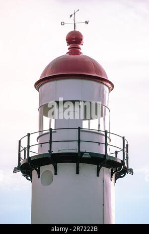 Ein majestätischer rot-weißer Leuchtturm steht hoch und stolz und zeigt nach oben in den Himmel Stockfoto