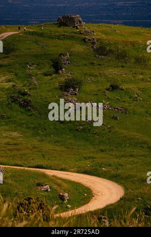 Ein männlicher Mountainbiker fährt auf einem malerischen Off-Road-Pfad mit der wunderschönen Kulisse des Ozeans Stockfoto