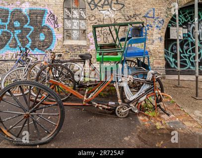 Kopenhagen, Dänemark - 14. September 2010: Christiania freetown. Ein Haufen gebrochenes Bicyclea vor einer graffiti-verputzten braunen Ziegelwand Stockfoto