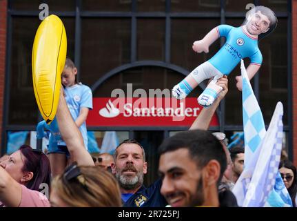 Ein Fan winkt vor der Treble Parade in Manchester mit einer aufblasbaren Puppe, die das Gesicht von Manchester Citys John Stones zeigt. Manchester City schloss die Treble (Champions League, Premier League und FA Cup) nach einem Sieg von 1-0 über Inter Mailand in Istanbul und sicherte ihnen den Ruhm der Champions League. Foto: Montag, 12. Juni 2023. Stockfoto