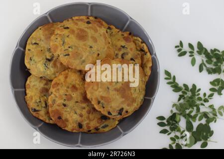 Daal Poor mit Moringa-Blättern. Frittiertes indisches Fladenbrot aus Vollweizenmehl, gekochten Linsen und Moringa-Blättern und Gewürzen. Auf weißem Ba geschossen Stockfoto