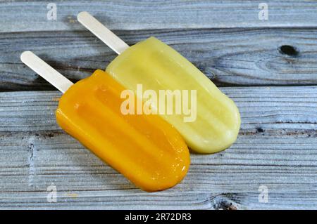 Gefrorene Eisstäbchen aus Mango und Ananas, cremige und köstliche gefrorene Desserts, Konzept der süßen Sommerzeiten, gefrorene Snacks mit Eis Stockfoto