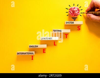IELTS-Symbol. Konzeptbegriffe IELTS internationales englischsprachiges Prüfsystem auf Holzblock. Wunderschöner gelber Hintergrund. Business IELTS internati Stockfoto