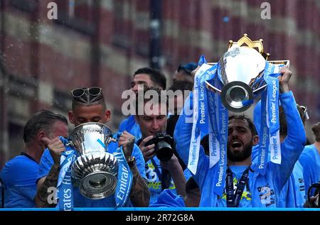 Manchester Citys Kalvin Phillips mit der Emirates FA Cup Trophäe und Bernardo Silva mit der Premier League Trophäe während der Treble Parade in Manchester. Manchester City schloss die Treble (Champions League, Premier League und FA Cup) nach einem Sieg von 1-0 über Inter Mailand in Istanbul und sicherte ihnen den Ruhm der Champions League. Foto: Montag, 12. Juni 2023. Stockfoto