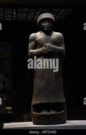 Eine Bronzeskulptur einer Frau, die im Louvre mit den Händen auf der Brust steht Stockfoto