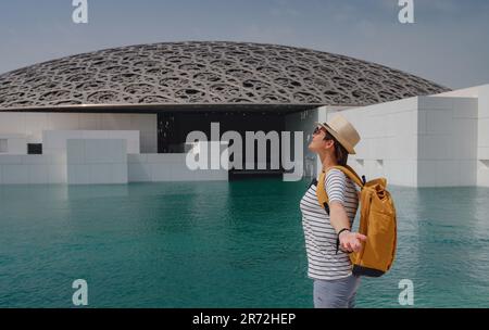 Abu Dhabi, Vereinigte Arabische Emirate - 21. März 2023 : weibliche Reisende in der Nähe des Louvre in Abu Dhabi, Vereinigte Arabische Emirate. Der Louvre ist ein neues Museum in den Vereinigten Arabischen Emiraten, das am 8. 2017. November eröffnet wurde Stockfoto