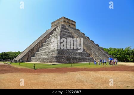 Touristen am Fuße des Schlosses, El Castillo oder der Pyramide von Kukulcan in Chichen Itza, Yucatan, Yucatan Halbinsel, Mexiko. Stockfoto