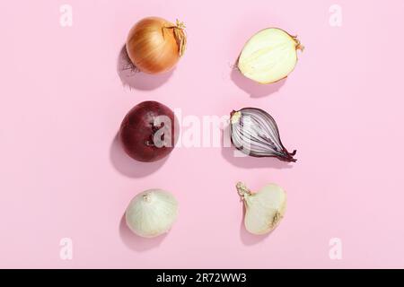 Verschiedene Zwiebelsorten auf pinkfarbenem Hintergrund Stockfoto