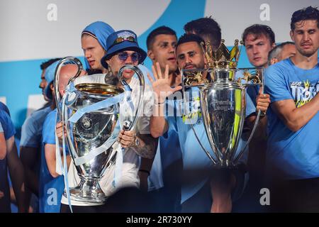 Riyad Mahrez #26 von Manchester City und Ederson #31 von Manchester City hebt die Champions League Trophäe und Premier League Trophäe auf der Bühne während der Manchester City's Treble Victory Parade am St. Peter's Square, Manchester, Großbritannien, 12. Juni 2023 (Foto von Mark Cosgrove/News Images) Stockfoto