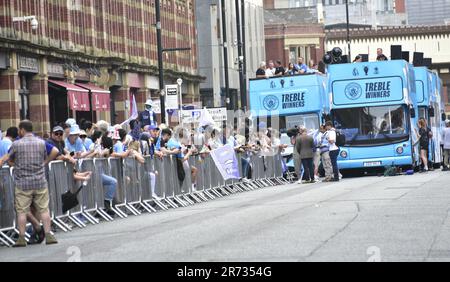 Manchester, Großbritannien. 12. Juni 2023. Die Fans warten, während der Manchester City Football Club sich auf eine Siegesparade mit offenem Oberdeck im Zentrum von Manchester vorbereitet, um den Sieg der Treble zu feiern: Die Premier League, den FA Cup und die Champions League. Am Samstag besiegte man City Inter Mailand in Istanbul und sicherte sich den Champions League-Sieg. Die Parade der offenen Busse fuhr durch das Stadtzentrum von Manchester und beobachtete von großen, begeisterten Massen, trotz Gewitter und starkem Regen. Kredit: Terry Waller/Alamy Live News Stockfoto