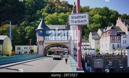 Brücke über die Mosel mit Fußgängern und Autos durch den mittelalterlichen Eingang der Stadt Trarbach. Stockfoto