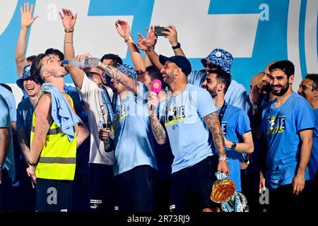 Manchester, Großbritannien. 12. Juni 2023. Kalvin Phillips gießt einen Drink in Jack Grealish's Mund, während die Spieler während ihrer Treble Winning Victory Parade, die im Rathaus in Manchester endet, zusehen. Foto: 12. Juni 2023. Das Bild sollte lauten: Gary Oakley/Sportimage Credit: Sportimage Ltd/Alamy Live News Stockfoto