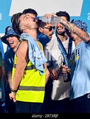 Manchester, Großbritannien. 12. Juni 2023. Kalvin Phillips gießt einen Drink in Jack Grealish's Mund, während die Spieler während ihrer Treble Winning Victory Parade, die im Rathaus in Manchester endet, zusehen. Foto: 12. Juni 2023. Das Bild sollte lauten: Gary Oakley/Sportimage Credit: Sportimage Ltd/Alamy Live News Stockfoto