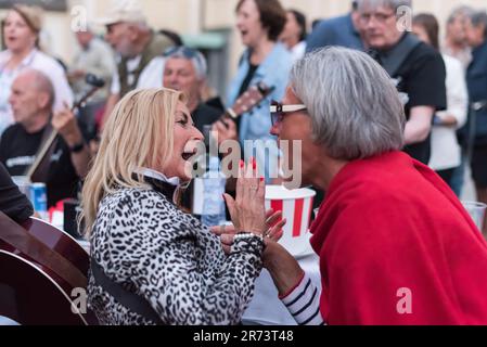 Prag, Tschechische Republik. 12. Juni 2023. Frauen, die beim Essen singen, sitzen an einem großen Tisch, der sich um die Kathedrale im Innenhof der Prager Burg befindet. Etwa 400 Meter langer Esstisch, in Herzform, wurde um den gesamten St. Veitsdom im Innenhof der Prager Burg. Die Veranstaltung wurde für alle als Symbol der Zusammengehörigkeit und Einheit der Einwohner und Besucher von Prag eröffnet. Kredit: SOPA Images Limited/Alamy Live News Stockfoto