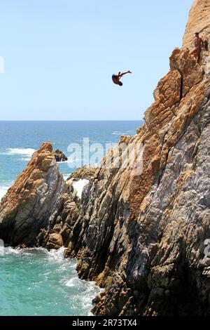 Acapulco, Guerrero, Mexiko - April 28 2023: Taucher von La Quebrada springen von einer 45 Meter hohen Klippe, sie sind die beliebteste Attraktion sehr alt Stockfoto