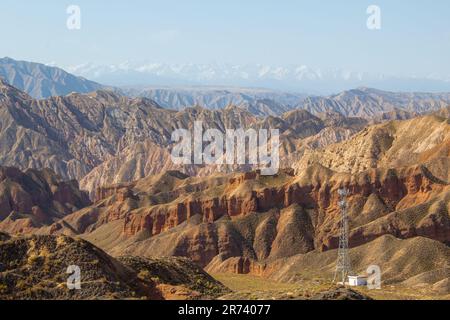 Luftaufnahme von Binggou Danxia Canyon Relief in Zhangye, Sunan Region, Provinz Gansu, China. Scharfe Spitzen Spitzen im Geopark. Niedrige Wolken und Blau Stockfoto