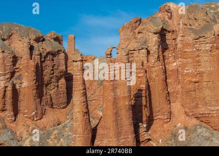 Die roten Felsformationen im Binggou Danxia Scenic Area in China sehen aus wie Skulpturen. Sonniger Tag mit blauem Himmel, Kopierbereich für Text Stockfoto