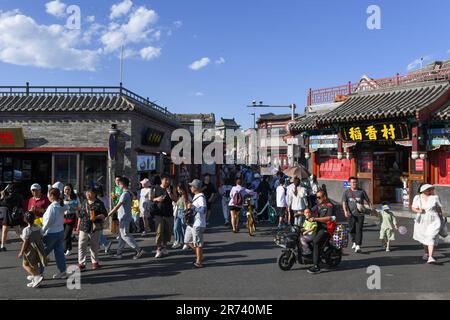 (230613) -- PEKING, 13. Juni 2023 (Xinhua) -- Touristen besuchen eine Handelsstraße in der Nähe des Shichahai-Sees im Zentrum von Peking, Hauptstadt von China, 9. Juni 2023. Die Pekinger Zentralachse, Zhongzhouxian, wurde ursprünglich in der Yuan-Dynastie (1271-1368) erbaut und erstreckt sich 7,8 Kilometer zwischen dem Yongding-Tor (Yongdingmen) im Süden der Stadt und dem Trommelturm und Glockenturm im Norden. Die meisten der wichtigsten alten Gebäude von Peking liegen entlang dieser Achse. Vierzehn historische Orte entlang der Achse, darunter Qianmen, die Verbotene Stadt, Jingshan Park, die Trommel- und Glockentürme und der Tian'anmen-Platz Stockfoto