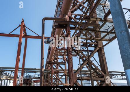 Alte rostige Rohre, Leitern und Rahmen sowie Metall in einer Industriearchitektur und Kommunikations- und Metallstrukturen Stockfoto