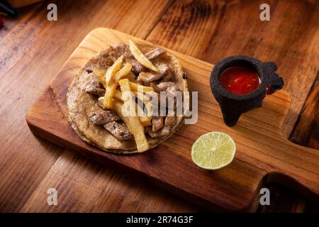 Steak-Taco mit pommes frites. Sehr beliebter Taco de Bistec oder Carne Asada in Mexiko, hausgemachtes Roastbeef auf einer Maistortilla. Ich Stockfoto