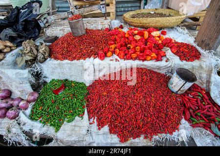 Toliara, Madagaskar - 01. Mai 2019: Getrocknete rote und grüne Paprika und Gewürze, in lebendigen Kontrastfarben, ausgestellt auf der Straße des Lebensmittelmarkts Stockfoto