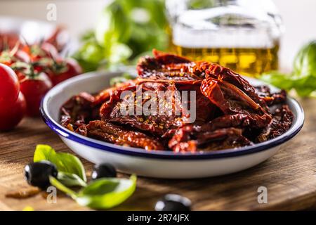 Sonnengetrocknete Tomaten, mariniert in Olivenöl mit Kräutern und Oliven. Stockfoto