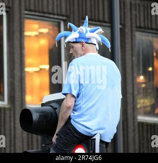 Manchester, Großbritannien. 12. Juni 2023. Ein man City-Fan sitzt an einer Ampel, um die Siegesparade mit offenem Oberdeck im Zentrum von Manchester, Großbritannien, zu sehen, um die Erfolge seines Clubs zu feiern, der die Höhen gewonnen hat: Die Premier League, der FA Cup und die Champions League. Am Samstag besiegte man City Inter Mailand in Istanbul und sicherte sich den Champions League-Sieg. Die Parade der offenen Busse fuhr durch das Stadtzentrum von Manchester und beobachtete von großen, begeisterten Massen, trotz Gewitter und starkem Regen. Kredit: Terry Waller/Alamy Live News Stockfoto