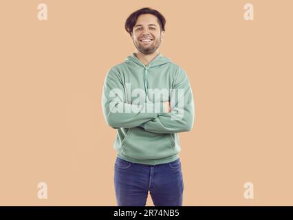 Porträt eines glücklichen jungen Mannes, der mit zusammengeklappten Armen steht Stockfoto