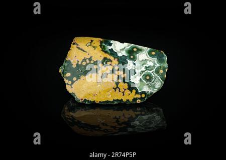 Orbiculärer Jasper (auch bekannt als Ocean Jasper), isoliert auf schwarzem Hintergrund. Textur für Makrodetails. Nahaufnahme polierter halbwertvoller Edelstein. Stockfoto