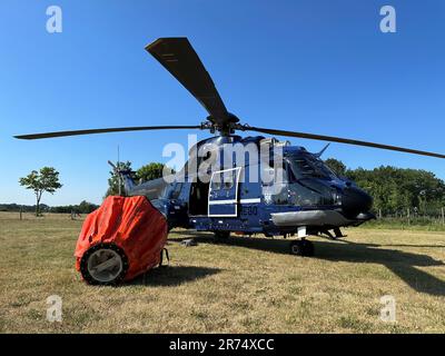 13. Juni 2023, Mecklenburg-Vorpommern, Lübtheen: Ein Hubschrauber, mit dem das Feuer auf einem ehemaligen militärischen Trainingsgelände aus der Luft bekämpft wurde, steht hinter einem Behälter für Löschwasser. Der Brand in der Nähe von Lübtheen hatte dazu geführt, dass die Bewohner eines Dorfes evakuiert werden mussten. Foto: Steven Hutchings/dpa Stockfoto