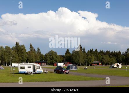 FRÖSÖN, SCHWEDEN AM 07. AUGUST 2015. Blick auf Camping, Wohnwagen, Auto und Zelte. Wolken und Schauer sind im Hintergrund. Editorial. Stockfoto