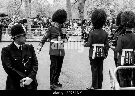 Ein Wächter inspiziert die Uniform Einer Fellow Guard vor der Königlichen Prozession, der Krönung von König Karl III., London, Großbritannien. Stockfoto