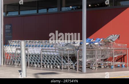 Reihen von miteinander verbundenen Supermarkt-Einkaufswagen vor einem Aldi's Store an der Gold Coast, Queensland, Australien. Neue, glänzende, silberne Trolleys. Stockfoto