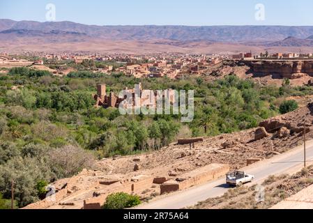 Alte verlassene große Kasbah auf einem Hügel, umgeben von einem Palmenhain im Tal der Rosen, Marokko Stockfoto