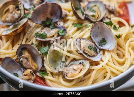 Spaghetti mit Muscheln, frischen Kirschtomaten, Petersilienblättern und gemahlenem schwarzen Pfeffer, Nahaufnahme Stockfoto