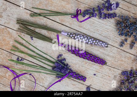 Englischer Lavendel (Lavandula angustifolia, Lavandula officinalis), Lavendelstangen, frischer Lavendel mit Satinband für Leinenschrank Stockfoto