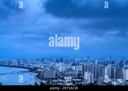 Blick aus der Vogelperspektive auf die Küstenstadt, Sanya, Hainan, China bei Nacht. Stockfoto