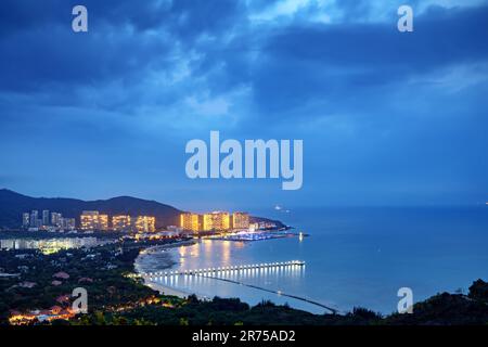 Blick aus der Vogelperspektive auf die Küstenstadt, Sanya, Hainan, China bei Nacht. Stockfoto