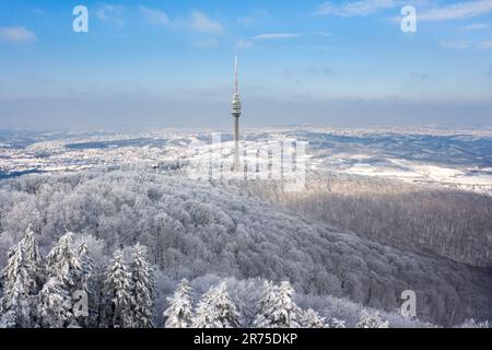 Ein Luftblick auf üppige schneebedeckte Wälder mit Avala Tower im Hintergrund. Beli Potok, Serbien. Stockfoto