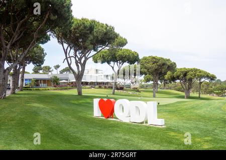 Blick auf das Clubhaus und üben Sie Putting Green, Quinta do lago, Algarve, Portugal mit dem Logo-Schild für den Golfplatz. Stockfoto