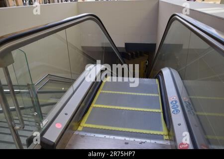 Rolltreppen führen zu einer U-Bahn-Haltestelle, die vom Eingang bis zur Haltestelle auf der Straße der Stadt zu sehen ist Stockfoto