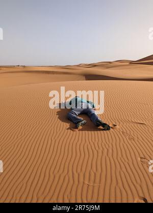 Eine Person, die tot in der Erg Chebbi Wüste in Marokko liegt Stockfoto