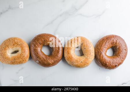 Vollkorn-Bagels mit Sesam auf einem Marmortisch Stockfoto