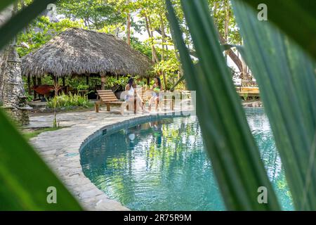 Nordamerika, Karibik, Großantillen, Hispaniola, Dominikanische Republik, North Coast, Puerto Plata Province, Cabarete, zwei hübsche Frauen, die sich am Pool des Boutique-Hotels Natura Cabana entspannen Stockfoto