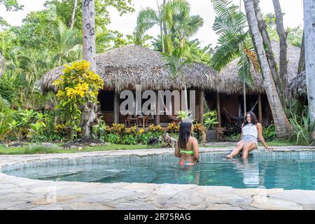 Nordamerika, Karibik, Großantillen, Hispaniola, Dominikanische Republik, North Coast, Puerto Plata Province, Cabarete, zwei hübsche Frauen, die sich am Pool des Boutique-Hotels Natura Cabana entspannen Stockfoto