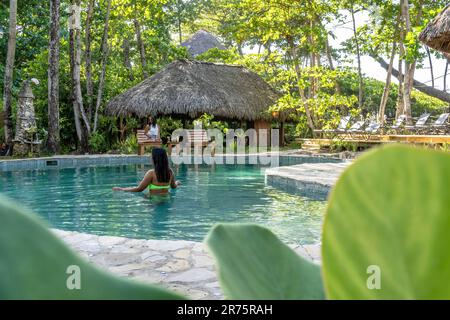 Nordamerika, Karibik, Großantillen, Hispaniola, Dominikanische Republik, North Coast, Puerto Plata Province, Cabarete, zwei hübsche Frauen, die sich am Pool des Boutique-Hotels Natura Cabana entspannen Stockfoto