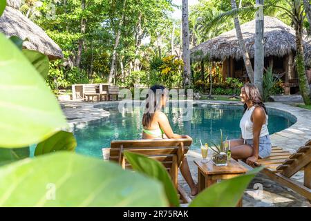 Nordamerika, Karibik, Großantillen, Hispaniola, Dominikanische Republik, North Coast, Puerto Plata Province, Cabarete, zwei hübsche Frauen, die sich am Pool des Boutique-Hotels Natura Cabana entspannen Stockfoto