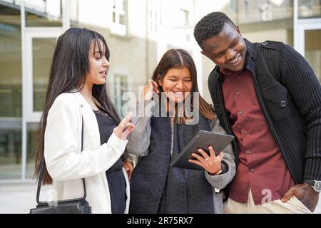 Gute Zusammenarbeit lateinamerikanischer und afrikanischer Geschäftsleute mit Technologie. Junge multiethnische und erfolgreiche Unternehmer mit einem Tablet Stockfoto