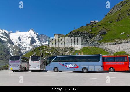 Busparkplatz mit Bussen am hohen Sattel, im Hintergrund der schneebedeckte Großglockner und der Kaiser-Franz-Josefs-Höhe Stockfoto